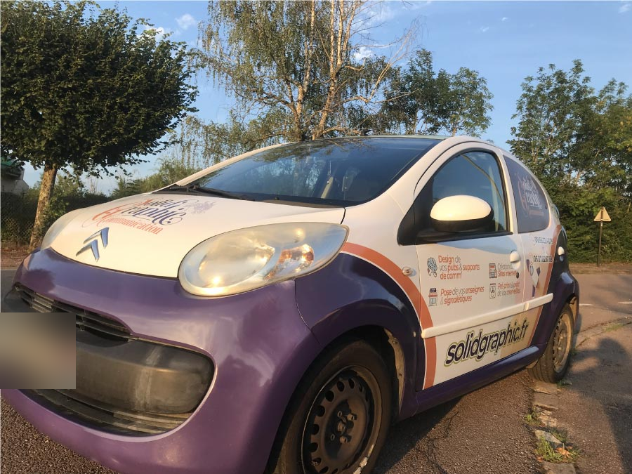 Marquage publicitaire de véhicule sur une Citroën Solidgraphic violet, blanc et orange